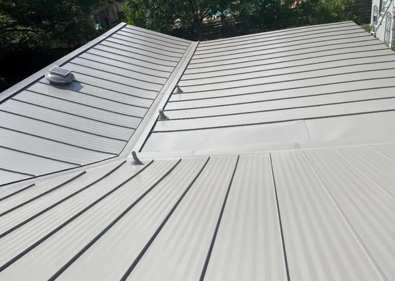 Solar attic fan installed on a metal roof for Roof Ventilation in Leland