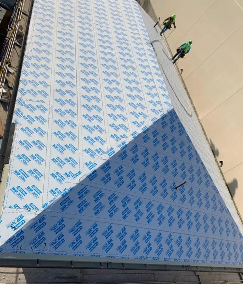 Professional roofers installing underlayment on a metal roof in Leland